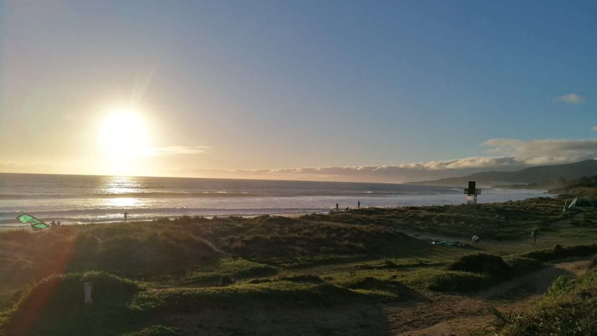 Evening sun, ocean, grass, beach, lifeguard tower and a kite