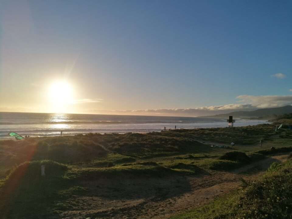 Evening sun, ocean, grass, beach, lifeguard tower and a kite