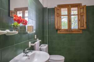 bathroom with green tiles and a window