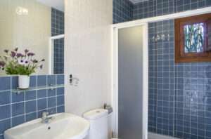 bathroom with shower and blue tiles