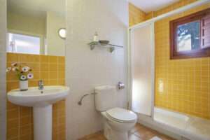 bright bathroom with shower and yellow tiles